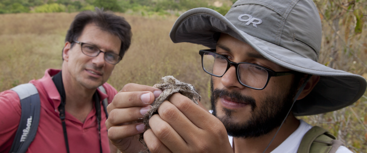 a student and mentor inspect a specimen out in the field