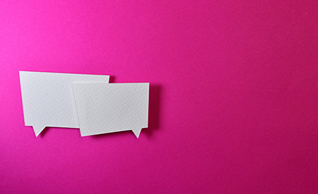 Two white cardboard conversation bubbles against a bright pink background