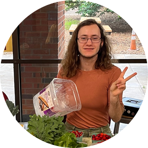 Rin Barnum gives a peace sign while selling veggies at an SOF farmer's market