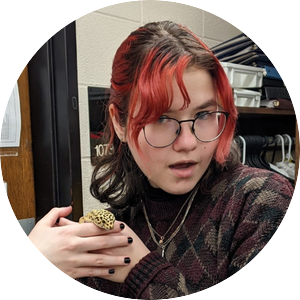 Trystan Schultz smiles demurely while holding a leopard gecko