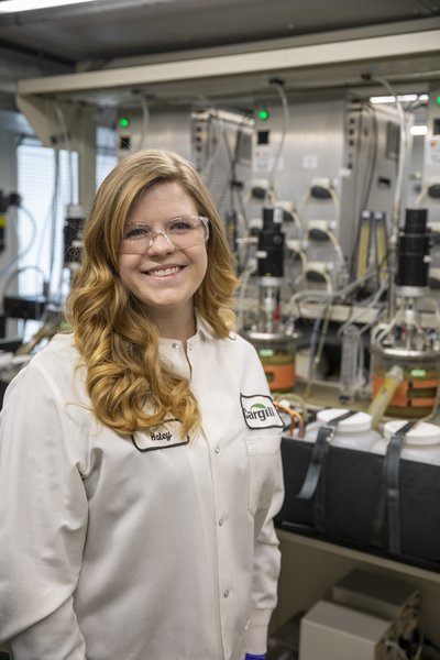 CFANS alumna Haley Larson stands near the artificial rumens she works with in her research at Cargill.