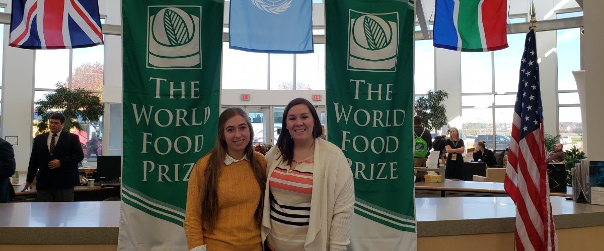 Lisa Orren and a student stand next to world food prize banners.