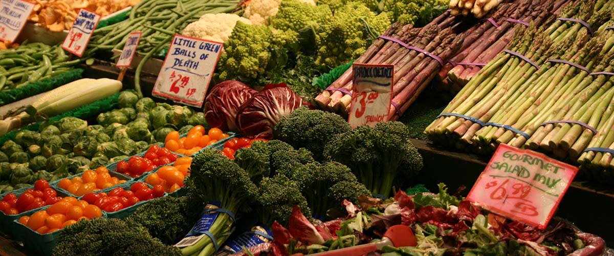 Farmer's market produce, including broccoli, asparagus, and cherry tomatoes.