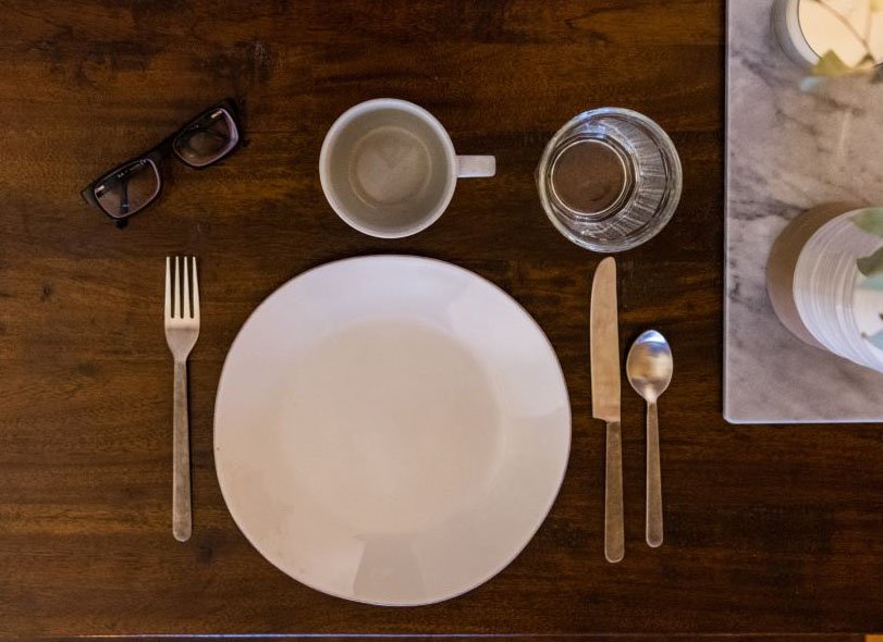 Place setting empty dishes at a table. 