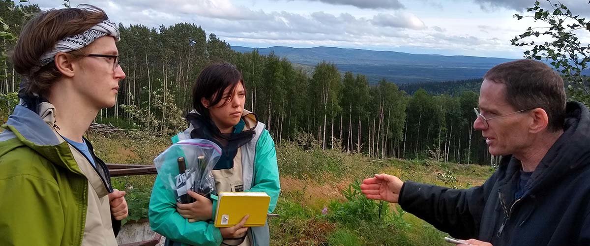 Tyler Baumann and Sara DeLaurentis talk with someone while collecting samples.