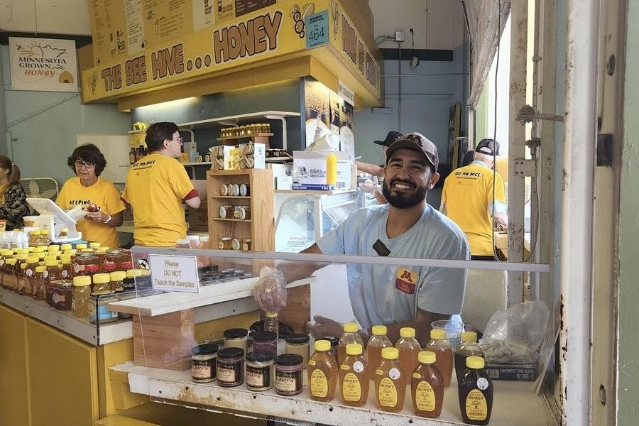 As an ambassador for the Minnesota Honey Producers, Joshua Muñoz offers tastes of local honey at the Minnesota State Fair.