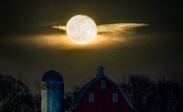 A warm full moon over a barn