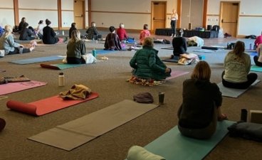 Several people sitting on yoga mats