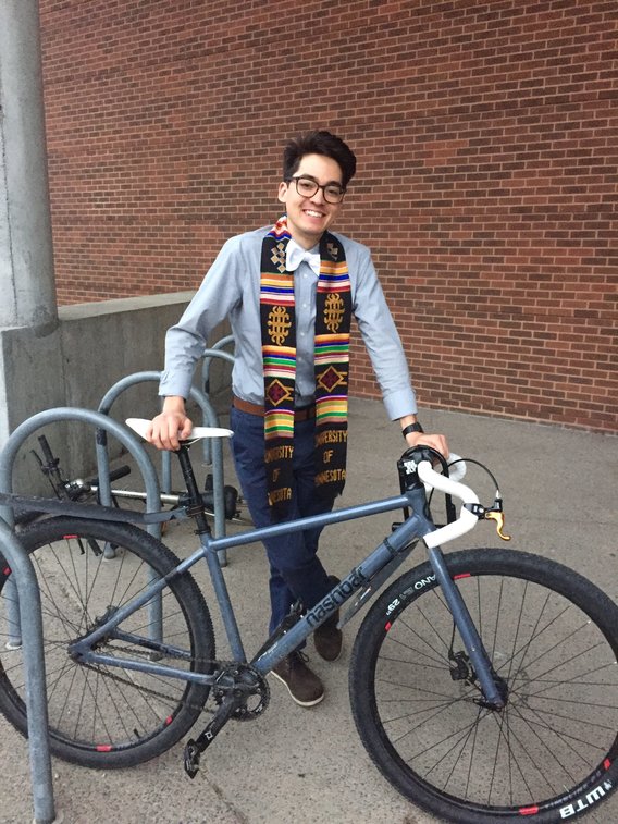 Applied economics alumnus Quentin IkutaSchodde standing near a bicycle.