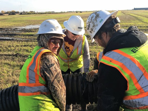Helping the crew from Ellingson Drainage join two pieces of drainage pipe together during installation in October 2019.