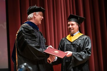 Alex Chase receiving his diploma from CFANS Dean Brian Buhr