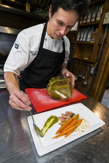 Alex Chase plating food in a commercial kitchen 