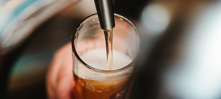 Beer from a tap being poured into a pint glass.