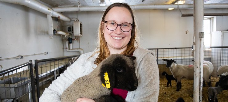 Animal science student Rheanna Iskierka holding a sheep.