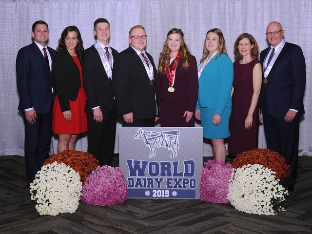 the dairy judging team stands behind a sign reading "world dairy expo 2019"