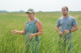 Anne and Peter Schwagerl stand in a Kernza field on their farm near Browns Valley, Minnesota. 