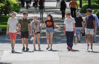 Six students walking on campus.