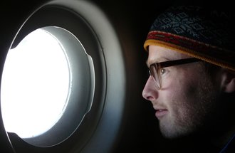 Peter Neff looking out an airplane window.