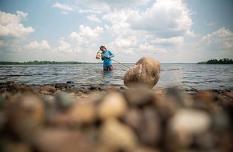 Professor Gretchen Hansen in a Minnesota lake while doing research.