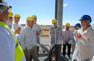 Nicole Atchison, CEO of Puris Holdings, far right, leads a tour of the company's Dawson plant for area lawmakers and staff with the University of Minnesota's Forever Green Initiative on Oct. 6, 2022.