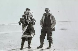 Minnesotan Margaret Oldenburg shown at a stop on her travels, apparently at a native village, possibly accompanied by a bush pilot that she traveled with often.