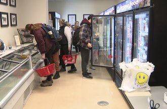Customers shopping in meat and dairy salesroom. 