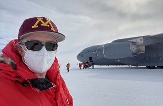 Professor Peter Neff in Antarctica wearing U of M hat, sunglasses and face mask.