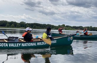 Nature for New Minnesotans participants in canoes on Lake Itasca.