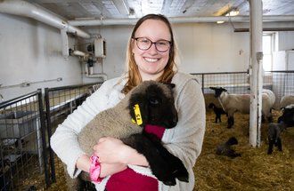 Animal science student Rheanna Iskierka holding a sheep.