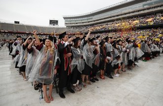 Graduates in Huntington Bank Stadium during undergraduate commencement