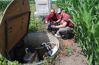 Fabian Fernandez and Zac Aanerud take a gas measurement next to a cornfield