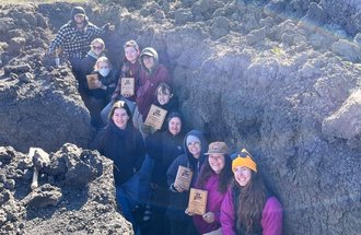 Soil Judging Team holding their awards in a soil pit