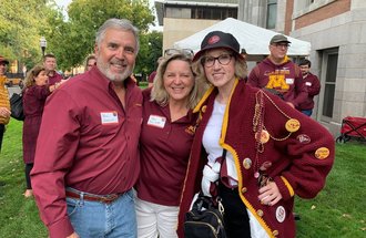 A photo of three people wearing maroon and gold